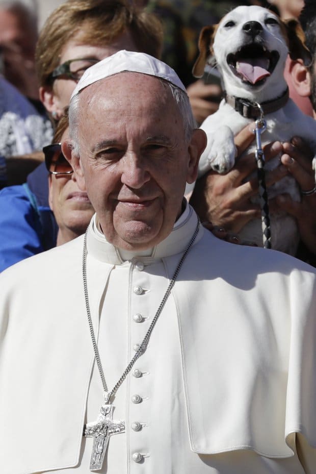 Pope Francis poses for photographers with a group of dog trainers, during his weekly general audience, in St. Peter's Square, at the Vatican, Wednesday, Oct. 5, 2016. (AP Photo/Andrew Medichini)